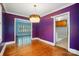 Dining room with purple walls, hardwood floors, and decorative chandelier at 4220 Castlewood Rd, Charlotte, NC 28209