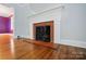 Close-up on fireplace featuring brick surround, white mantle, and hardwood floors at 4220 Castlewood Rd, Charlotte, NC 28209