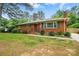 Traditional brick home with a manicured front lawn, trimmed bushes, and an American flag at 4220 Castlewood Rd, Charlotte, NC 28209