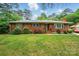 Charming single-story brick home featuring a well-maintained lawn and traditional green shutters at 4220 Castlewood Rd, Charlotte, NC 28209