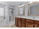 This primary bathroom has double vanity sinks with framed mirrors and a standing glass door shower at 4531 Dalbeth St, Charlotte, NC 28213