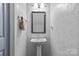 Charming bathroom featuring a pedestal sink, decorative mirror, and textured walls at 4531 Dalbeth St, Charlotte, NC 28213