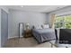 Cozy bedroom features a comfortable bed, a window with natural light, and closet with bi-fold doors at 4531 Dalbeth St, Charlotte, NC 28213