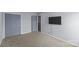 Bedroom featuring an air vent, closet doors, carpet, a window, and a mounted TV at 4531 Dalbeth St, Charlotte, NC 28213