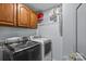 Laundry room featuring modern appliances, wooden cabinets, and wire rack shelving at 4531 Dalbeth St, Charlotte, NC 28213
