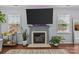 Cozy living room showcasing a fireplace, mounted TV, and natural light from nearby windows at 4531 Dalbeth St, Charlotte, NC 28213