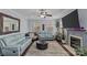 Comfortable living room featuring soft blue couches, a fireplace, and a ceiling fan at 4531 Dalbeth St, Charlotte, NC 28213