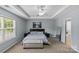 Bright main bedroom with a tray ceiling, soft lighting, and a stylish ottoman at 4531 Dalbeth St, Charlotte, NC 28213