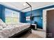 This is a spacious bedroom that has a canopy bed and blue walls with a TV on the wall and 2 shelves at 4619 Glasgow Ct, Gastonia, NC 28056
