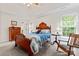 Cozy bedroom with a decorative wooden bed frame, ceiling fan, and ample natural light from the window at 4619 Glasgow Ct, Gastonia, NC 28056