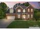 Charming two-story brick home with well-manicured lawn and attached two-car garage enhanced for virtual dusk at 4619 Glasgow Ct, Gastonia, NC 28056