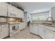 Traditional kitchen features white appliances, tile backsplash, ample counter space, and plenty of natural light at 4619 Glasgow Ct, Gastonia, NC 28056