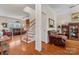 Inviting living room featuring hardwood floors, a cozy leather chair, and a staircase at 4619 Glasgow Ct, Gastonia, NC 28056