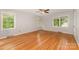 Bright, empty bedroom with wood floors and three large windows bringing in great light at 507 Richards Dr, Shelby, NC 28150