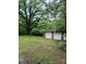 Detached two car garage with white doors and brick accents surrounded by mature trees at 514 N Main St, Mount Gilead, NC 27306