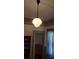 Hanging mid-century modern light fixture with floral wallpaper and molding detail at 514 N Main St, Mount Gilead, NC 27306