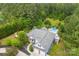 Aerial view of a home with a pool, lush landscaping, two car garage, and blue exterior at 5418 Commodore Pl, Clover, SC 29710