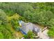 Aerial shot of a blue house nestled in trees with a pool, sprawling lawn, and two car garage at 5418 Commodore Pl, Clover, SC 29710
