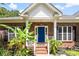 Inviting home featuring a bright blue front door, brick steps, and lush tropical landscaping at 5418 Commodore Pl, Clover, SC 29710