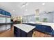 Open kitchen with stainless appliances, custom blue cabinets, and hardwood floors at 5418 Commodore Pl, Clover, SC 29710