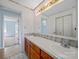 A bathroom with a double sink, wooden cabinets, decorative wallpaper border, and an open doorway at 55 Dixie Dr, Taylorsville, NC 28681