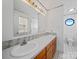 Bathroom featuring a double sink vanity with a large mirror, decorative tile accents, and an octagon window at 55 Dixie Dr, Taylorsville, NC 28681