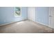A cozy bedroom has neutral carpet and a bright window, with a closet nearby at 55 Dixie Dr, Taylorsville, NC 28681
