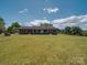 Expansive front lawn of a brick home under a bright sky with fluffy white clouds at 55 Dixie Dr, Taylorsville, NC 28681