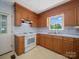 A kitchen boasts wooden cabinets and white appliances, with a door to the outside for convenience at 55 Dixie Dr, Taylorsville, NC 28681