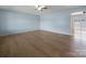 Spacious living room featuring light blue walls, hardwood flooring, and a ceiling fan at 55 Dixie Dr, Taylorsville, NC 28681