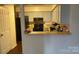 A view of the kitchen with black appliances and light blue cabinets from the living room at 5718 Dockside Dr, Charlotte, NC 28227