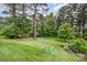 Lush backyard featuring mature trees, manicured lawn, and garden beds at 6309 Fawn Crest Dr, Waxhaw, NC 28173