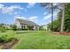 Manicured backyard features a lush lawn, mature trees, and a covered patio for outdoor enjoyment at 6309 Fawn Crest Dr, Waxhaw, NC 28173