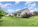 Expansive backyard with well-maintained lawn, mature trees, and a covered patio perfect for relaxation at 6309 Fawn Crest Dr, Waxhaw, NC 28173