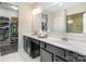 Bright bathroom with double vanity, large mirror, and a walk-in closet filled with clothing and shoes at 6309 Fawn Crest Dr, Waxhaw, NC 28173
