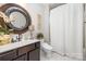 Stylish bathroom with a large round mirror, modern toilet, and a white shower curtain at 6309 Fawn Crest Dr, Waxhaw, NC 28173