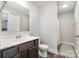 Bright bathroom features a wood vanity, large mirror, and a shower with white tiling at 6309 Fawn Crest Dr, Waxhaw, NC 28173