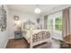 Inviting bedroom featuring decorative metal bed frame, light colored walls, and hardwood floors at 6309 Fawn Crest Dr, Waxhaw, NC 28173