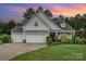 Charming home with three-car garage, manicured lawn, and beautiful sunset backdrop at 6309 Fawn Crest Dr, Waxhaw, NC 28173