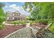 Scenic backyard with lush landscaping, a stone patio, and outdoor seating, perfect for entertaining at 6831 Conservatory Ln, Charlotte, NC 28210