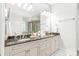 Bright bathroom featuring a double sink vanity with granite countertops and a large mirror at 6831 Conservatory Ln, Charlotte, NC 28210