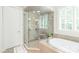 Bright bathroom featuring a soaking tub, glass walk-in shower and large window at 6831 Conservatory Ln, Charlotte, NC 28210