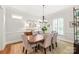 Formal dining room with wainscoting, a chandelier, and large windows, perfect for entertaining at 6831 Conservatory Ln, Charlotte, NC 28210