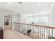 Open hallway overlooking the living room, features wood and iron railing and recessed lighting at 6831 Conservatory Ln, Charlotte, NC 28210