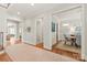 Well-lit hallway showcasing hardwood floors and access to a powder room and dining area, ensuring easy flow at 6831 Conservatory Ln, Charlotte, NC 28210