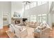 Bright living room featuring high ceilings, stone fireplace, and a large set of windows leading to the backyard at 6831 Conservatory Ln, Charlotte, NC 28210