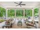 Covered patio with comfortable seating, ceiling fan, and a beautiful view of the landscaped backyard at 6831 Conservatory Ln, Charlotte, NC 28210