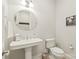 Clean powder room with a pedestal sink, oval mirror, and modern fixtures for guests' convenience at 6831 Conservatory Ln, Charlotte, NC 28210