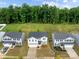 Aerial view of three two-story homes with manicured lawns and driveways in a suburban setting at 703 Pointe Andrews Dr, Concord, NC 28025