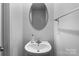 Half bathroom featuring a modern sink and stylish mirror at 703 Pointe Andrews Dr, Concord, NC 28025